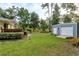 View of backyard, with grill, fire pit, and storage shed on lush, green lawn at 10804 Bounty St, New Port Richey, FL 34654