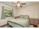 Comfortable bedroom features a ceiling fan, a window, and wood furniture at 10804 Bounty St, New Port Richey, FL 34654