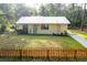 Charming single-story home with metal roof, tidy lawn, and a decorative picket fence at 10804 Bounty St, New Port Richey, FL 34654