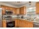 Galley kitchen with stainless steel appliances, wood cabinets and granite countertops at 10804 Bounty St, New Port Richey, FL 34654