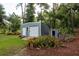 Durable backyard storage shed with roll up door and conventional door, surrounded by greenery at 10804 Bounty St, New Port Richey, FL 34654