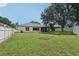 Spacious backyard featuring lush green grass, large tree, and white fencing at 10905 Wildcat Dr, Riverview, FL 33579