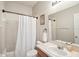 Cozy bathroom with a white shower curtain, single sink vanity and a framed painting at 10905 Wildcat Dr, Riverview, FL 33579