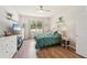 Bright bedroom featuring wood floors, ceiling fan, and window views at 10905 Wildcat Dr, Riverview, FL 33579
