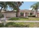 Charming single-story home features a well-maintained lawn, arched entryway, and attached two-car garage at 10905 Wildcat Dr, Riverview, FL 33579