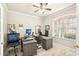 Bright home office featuring a large window, ceiling fan, and spacious desk setup at 10905 Wildcat Dr, Riverview, FL 33579