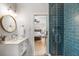 Modern bathroom with blue tiled shower and a view into the beach themed bedroom, creating a serene spa-like feel at 111 29Th W St, Bradenton, FL 34205