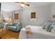 Bedroom featuring hardwood floors, woven shades, and comfortable furnishings including a couch and bed at 111 29Th W St, Bradenton, FL 34205