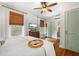 Sunlit bedroom with hardwood floors, woven shades, and a cozy aesthetic enhanced by a ceiling fan at 111 29Th W St, Bradenton, FL 34205