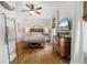 Bright bedroom with hardwood floors, ceiling fan, and beach-themed decor; offering a cozy and inviting space at 111 29Th W St, Bradenton, FL 34205