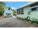 View of the house exterior featuring a garage with mural, pool, and lush greenery at 111 29Th W St, Bradenton, FL 34205