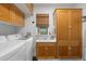 Well-lit laundry room with wooden cabinets, a sink, and a window that offers natural light at 111 29Th W St, Bradenton, FL 34205