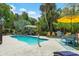 Beautiful pool area with lush tropical landscaping, lounge seating, and a dining set, creating a private oasis at 111 29Th W St, Bradenton, FL 34205