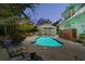 Evening view of the pool area, featuring ambient lighting and lush tropical landscaping at 111 29Th W St, Bradenton, FL 34205