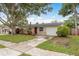 Attractive single-story home with red door, garage, and mature landscaping at 11320 125Th Ter, Largo, FL 33778