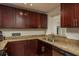 Well-lit kitchen featuring granite countertops and dark wood cabinetry at 11320 125Th Ter, Largo, FL 33778