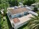 Aerial view showcasing a fenced backyard with brick-paved patio and blue home featuring solar panels at 11521 Paperwood Pl, Riverview, FL 33579