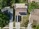 Aerial view of a home with solar panels, fenced yard, brick patio, nearby trees and driveway with parking at 11521 Paperwood Pl, Riverview, FL 33579