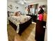 Well-lit bedroom with patterned bedding, side tables and dresser at 11521 Paperwood Pl, Riverview, FL 33579