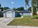 A cozy blue house with a one-car garage and solar panels, complete with a neatly paved driveway at 11521 Paperwood Pl, Riverview, FL 33579
