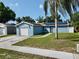 A quaint blue house showcases solar panels, a one-car garage, and a tidy front yard, offering suburban charm at 11521 Paperwood Pl, Riverview, FL 33579