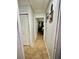 Bright hallway with neutral paint, tile flooring, and a view leading to a bedroom at 11521 Paperwood Pl, Riverview, FL 33579