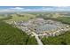 An aerial view shows a lake community surrounded by trees and field at 12026 Crestridge Loop, New Port Richey, FL 34655