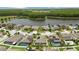 Scenic aerial view of homes near a lake, with lush trees and green spaces in the background at 12026 Crestridge Loop, New Port Richey, FL 34655