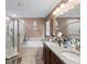 Bathroom featuring dual vanity sinks, granite countertops, a garden tub and a glass shower at 12026 Crestridge Loop, New Port Richey, FL 34655