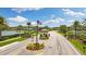 Community entrance with guardhouse, American flag, and manicured landscaping at 12026 Crestridge Loop, New Port Richey, FL 34655
