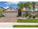 Inviting home with well-manicured lawn, palm trees, and a brick driveway leading to a two-car garage at 12026 Crestridge Loop, New Port Richey, FL 34655