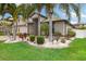 Well-maintained front yard featuring vibrant green grass, tropical landscaping, and decorative stone accents at 12026 Crestridge Loop, New Port Richey, FL 34655
