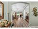 Open-concept hallway featuring hardwood floors, arched doorways, and seamless transitions between living spaces at 12026 Crestridge Loop, New Port Richey, FL 34655
