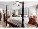 Relaxing bedroom featuring a four-poster bed, hardwood floors, and en suite bathroom at 12026 Crestridge Loop, New Port Richey, FL 34655