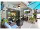 Covered patio with outdoor seating, a ceiling fan, a tv, and lush landscaping at 12026 Crestridge Loop, New Port Richey, FL 34655