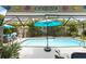 Screened in pool with patio area, lush landscaping, and outdoor seating at 12026 Crestridge Loop, New Port Richey, FL 34655