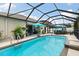 Gorgeous caged pool area features a refreshing swimming pool and outdoor seating under a sunny sky at 12026 Crestridge Loop, New Port Richey, FL 34655