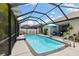 Inviting caged pool and patio area with sunny skies, an outdoor dining area, and garden accents at 12026 Crestridge Loop, New Port Richey, FL 34655