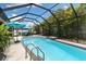 Inviting screened in swimming pool with ample patio seating and lush tropical landscaping offers a private oasis at 12026 Crestridge Loop, New Port Richey, FL 34655