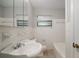 Traditional bathroom with white tile, vanity, toilet and a window for natural light at 1217 W Terrace Dr, Plant City, FL 33563
