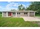 Charming single-story home featuring a well-maintained lawn, a red front door, and an attached single-car garage at 1217 W Terrace Dr, Plant City, FL 33563