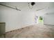 View of a well-lit garage featuring a roll-up door and additional outdoor access at 1217 W Terrace Dr, Plant City, FL 33563