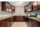 Updated kitchen with stainless steel appliances, dark wood cabinets, and tile flooring at 1217 W Terrace Dr, Plant City, FL 33563