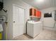 A well-equipped laundry room with a washer, dryer, storage cabinets, and a utility sink at 1217 W Terrace Dr, Plant City, FL 33563