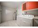 Bright laundry area featuring a washer, dryer, water heater, and practical storage at 1217 W Terrace Dr, Plant City, FL 33563