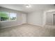 Bright living room with tile flooring, neutral walls, a large window, and a white front door at 1217 W Terrace Dr, Plant City, FL 33563