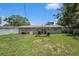 The backyard is a vast lawn with a patio featuring an awning and grill at the rear of the house at 1312 S Evergreen Ave, Clearwater, FL 33756