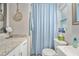 Bathroom with granite counters, blue chevron shower curtain, and updated fixtures at 1312 S Evergreen Ave, Clearwater, FL 33756