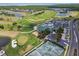 Stunning aerial view of a golf course community, with tennis courts, pool, and beautiful landscaping at 13636 Lake Point S Dr, Clearwater, FL 33762