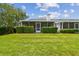Well maintained backyard featuring lush green grass and a screened-in porch at 13636 Lake Point S Dr, Clearwater, FL 33762